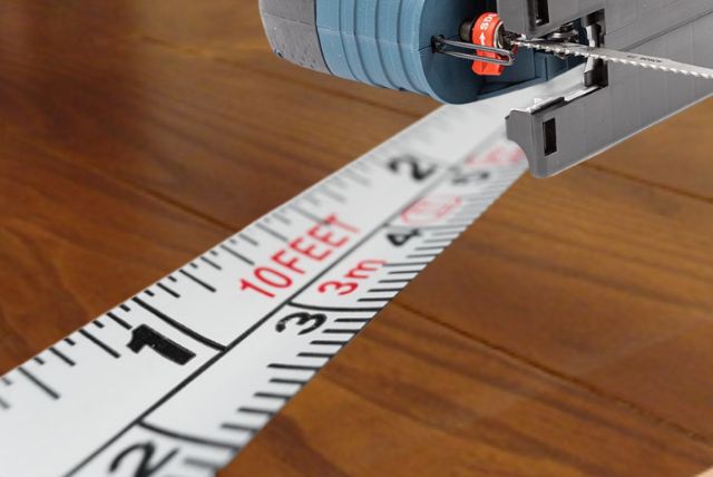 measuring a laminated countertop before using a jigsaw to cut straightlines